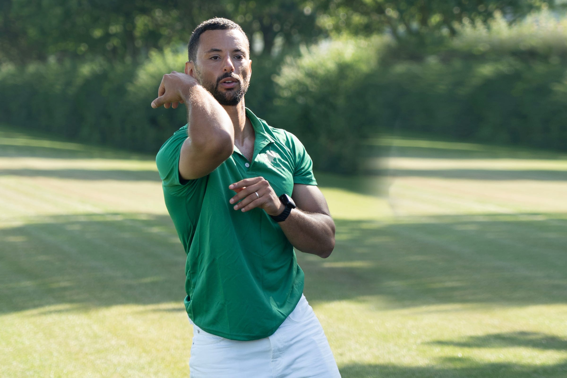 Coach releasing a rotational medicine-ball throw on the polo ground, the ball in flight